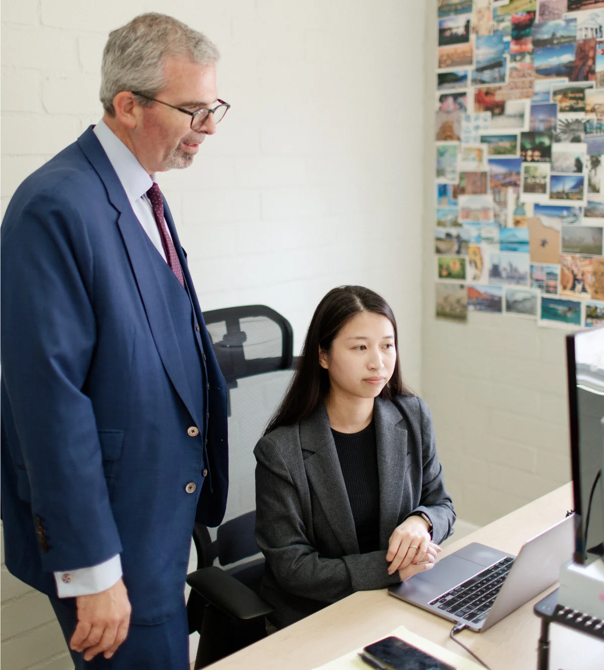 a man (Alphonse) and woman (Qi Jing) looking at a computer