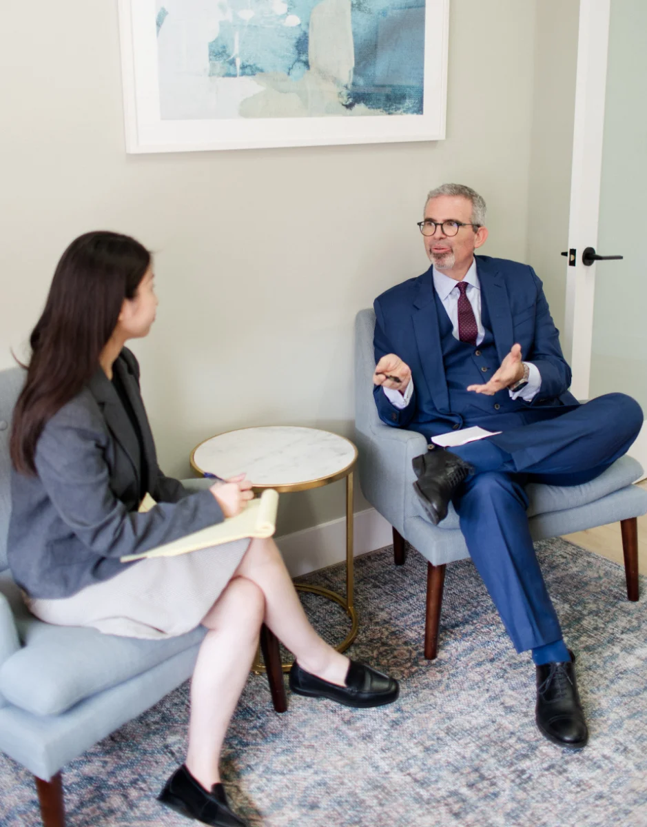 a man and woman sitting in chairs talking