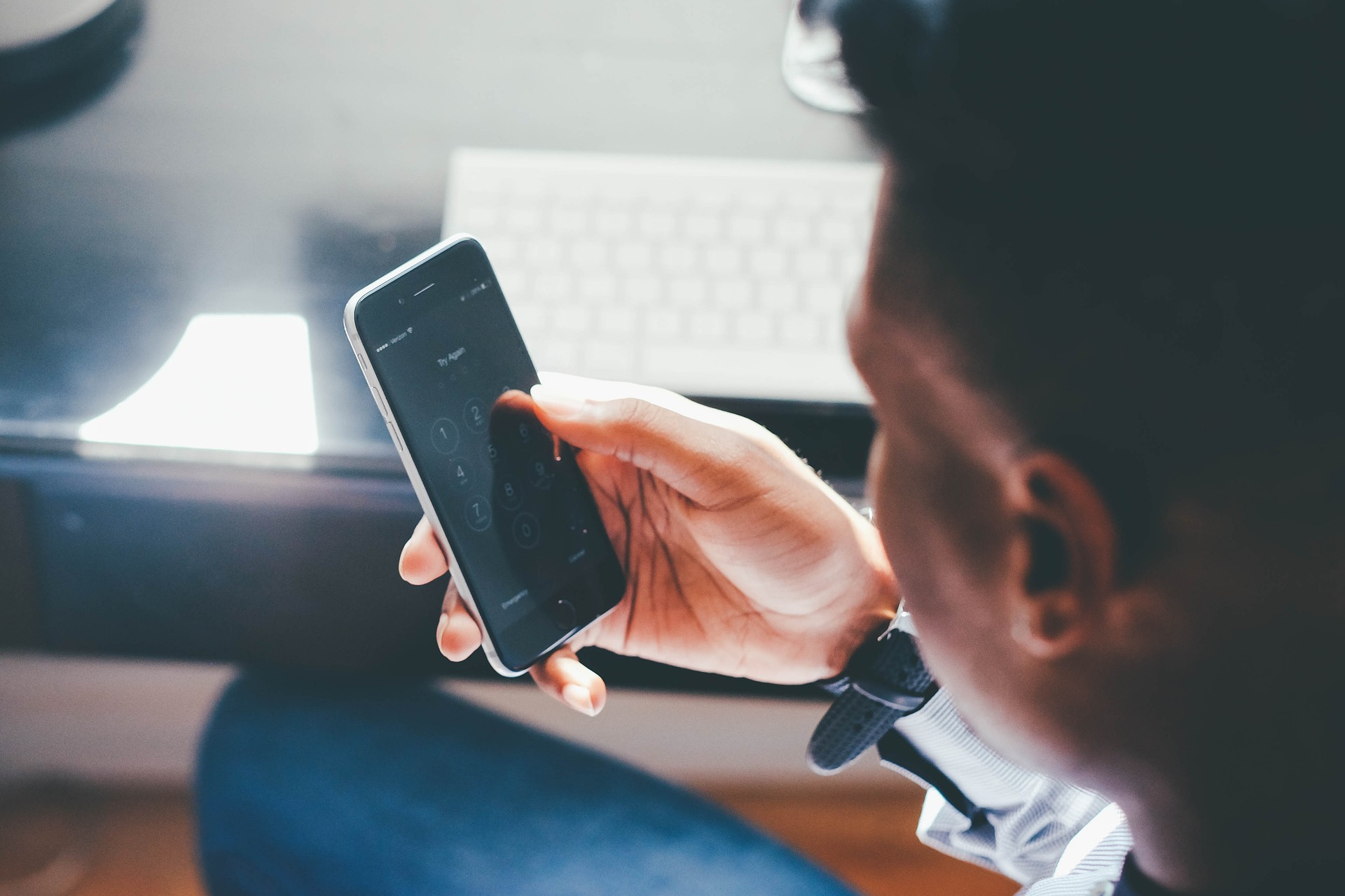 Person holding a smartphone with a locked screen, potentially dealing with restricted access due to online harassment.