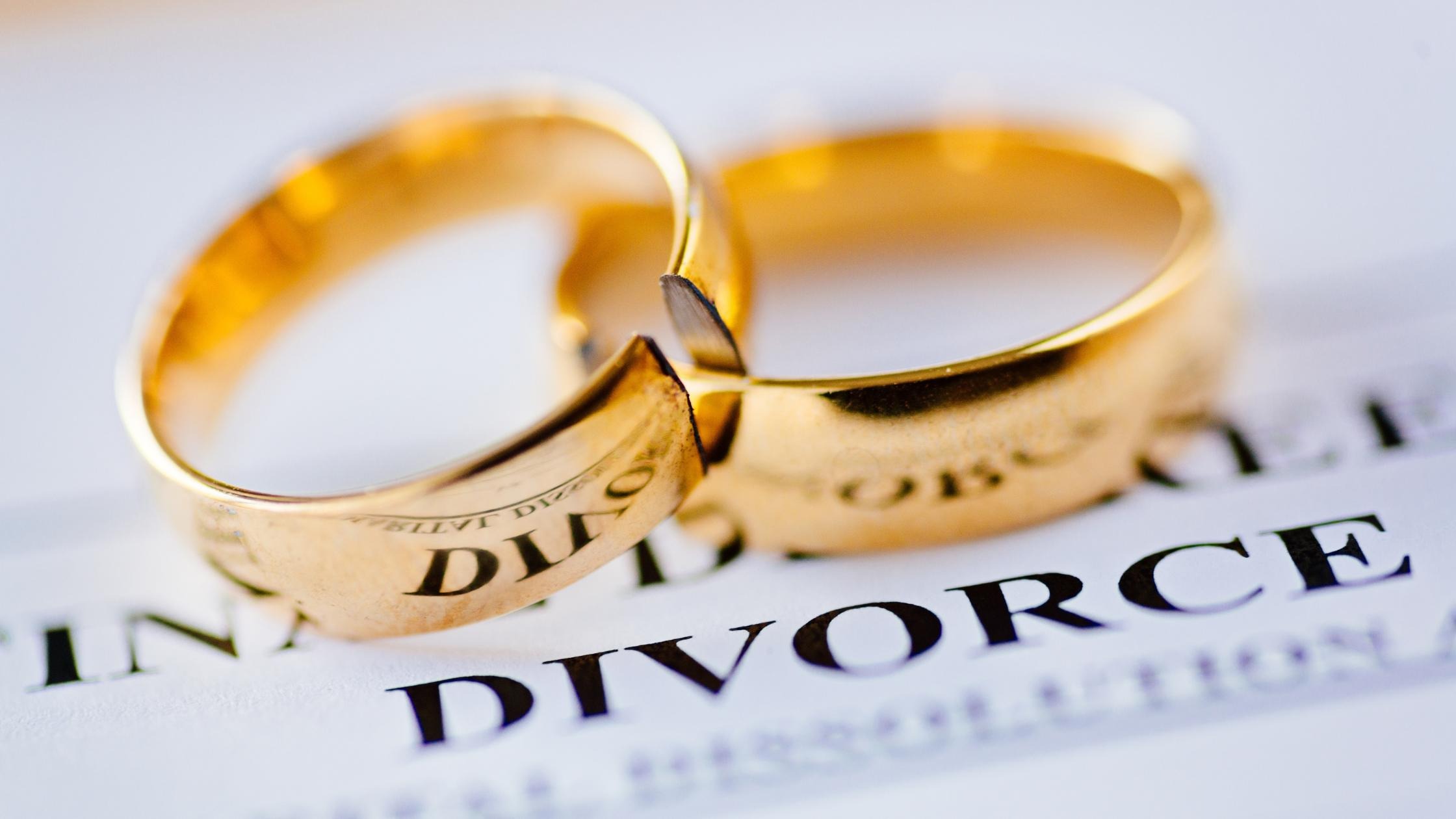 Broken wedding ring on a divorce document symbolizing adultery and divorce